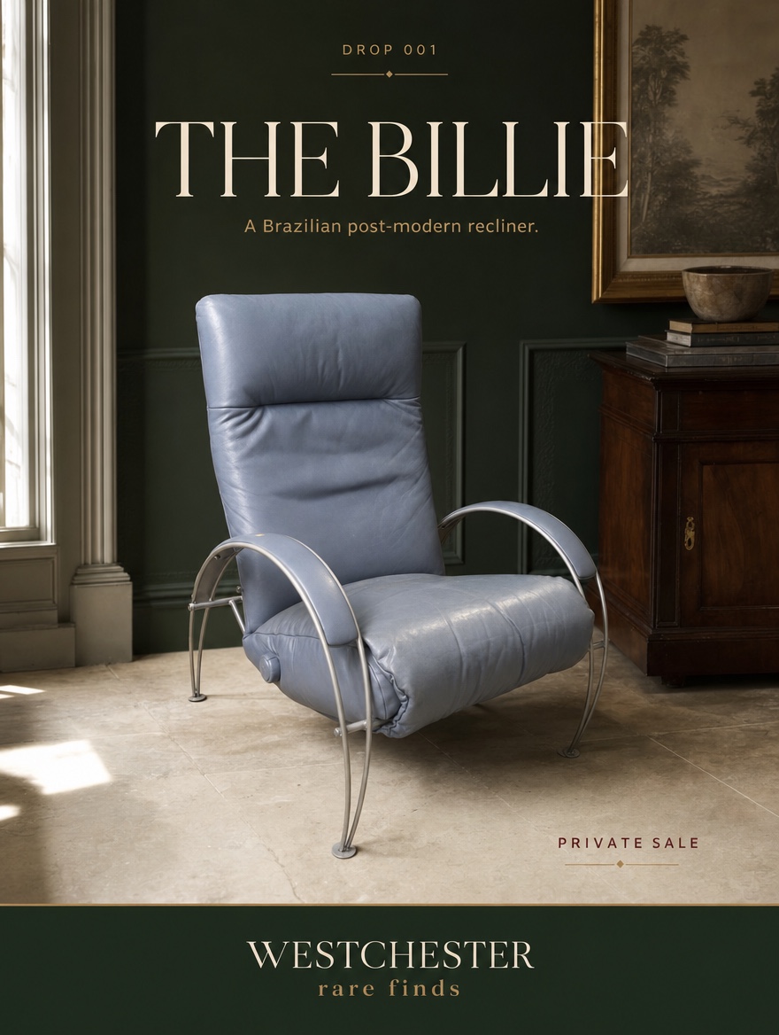 The blue-gray Lafer Billie recliner presented in a dark green editorial interior